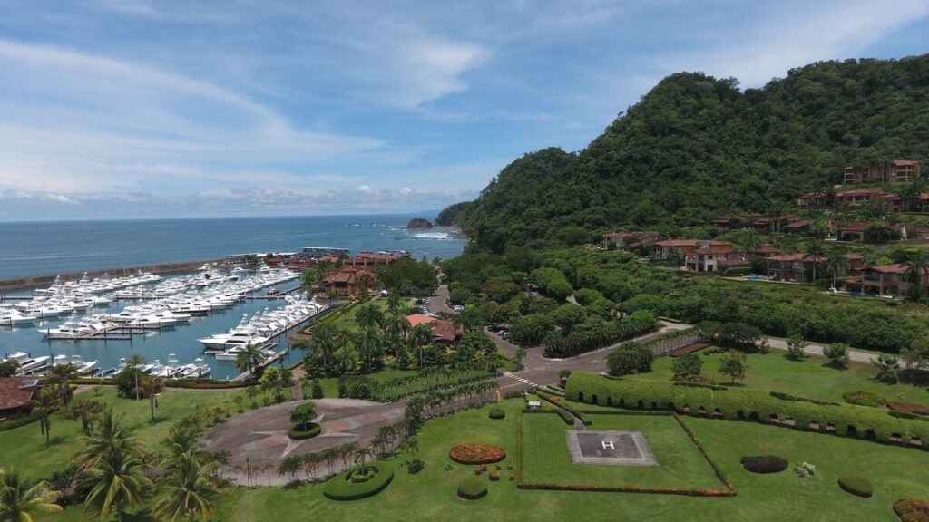 An aerial view of Los Sueños Marina set along the Pacific coastline, surrounded by lush hills and resort residences.