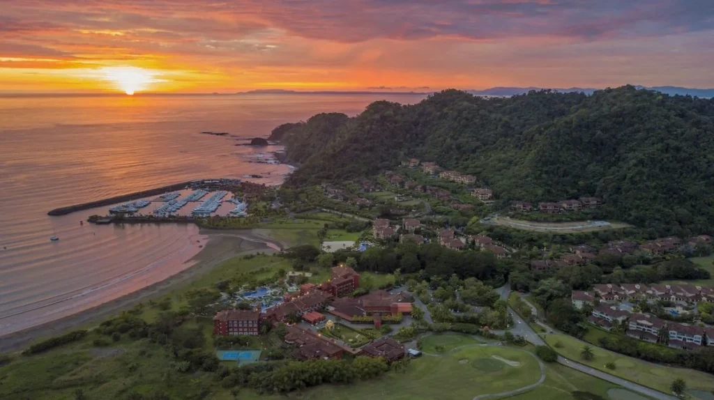 Aerial sunset view of Los Sueños Resort, where the marina, coastline, and lush tropical hills come together along Costa Rica’s Pacific coast.