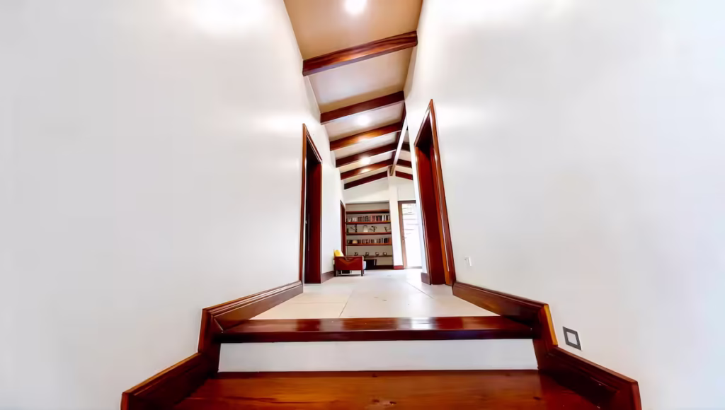 A bright hallway with vaulted ceilings connects the bedroom wing, creating an open and welcoming flow throughout the home.
