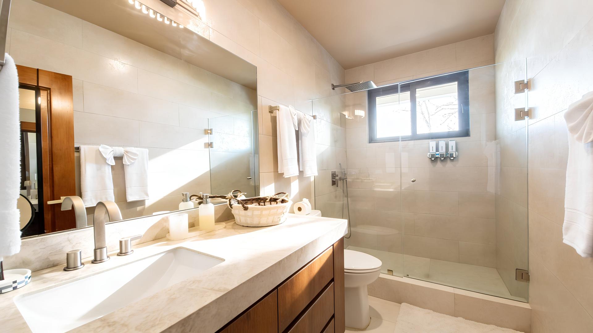 Luxury bathroom with walk-in rainfall shower and stone vanity in a Costa Rica beachfront villa