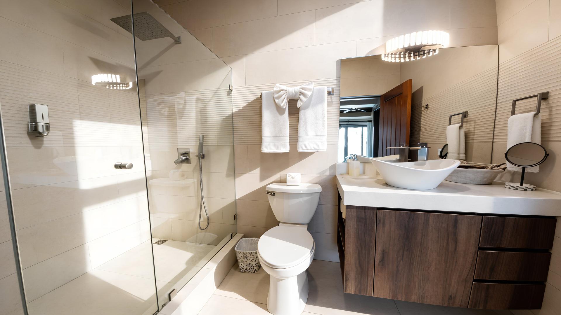Modern ensuite bathroom with walk-in glass rainfall shower in a Costa Rica luxury beachfront villa