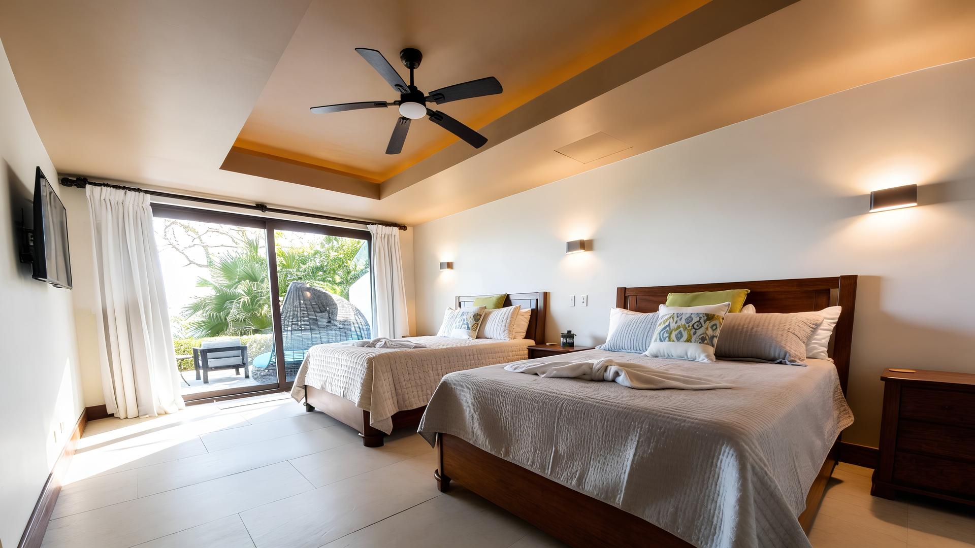 Guest bedroom with two queen beds and private terrace in a Costa Rica luxury beachfront villa