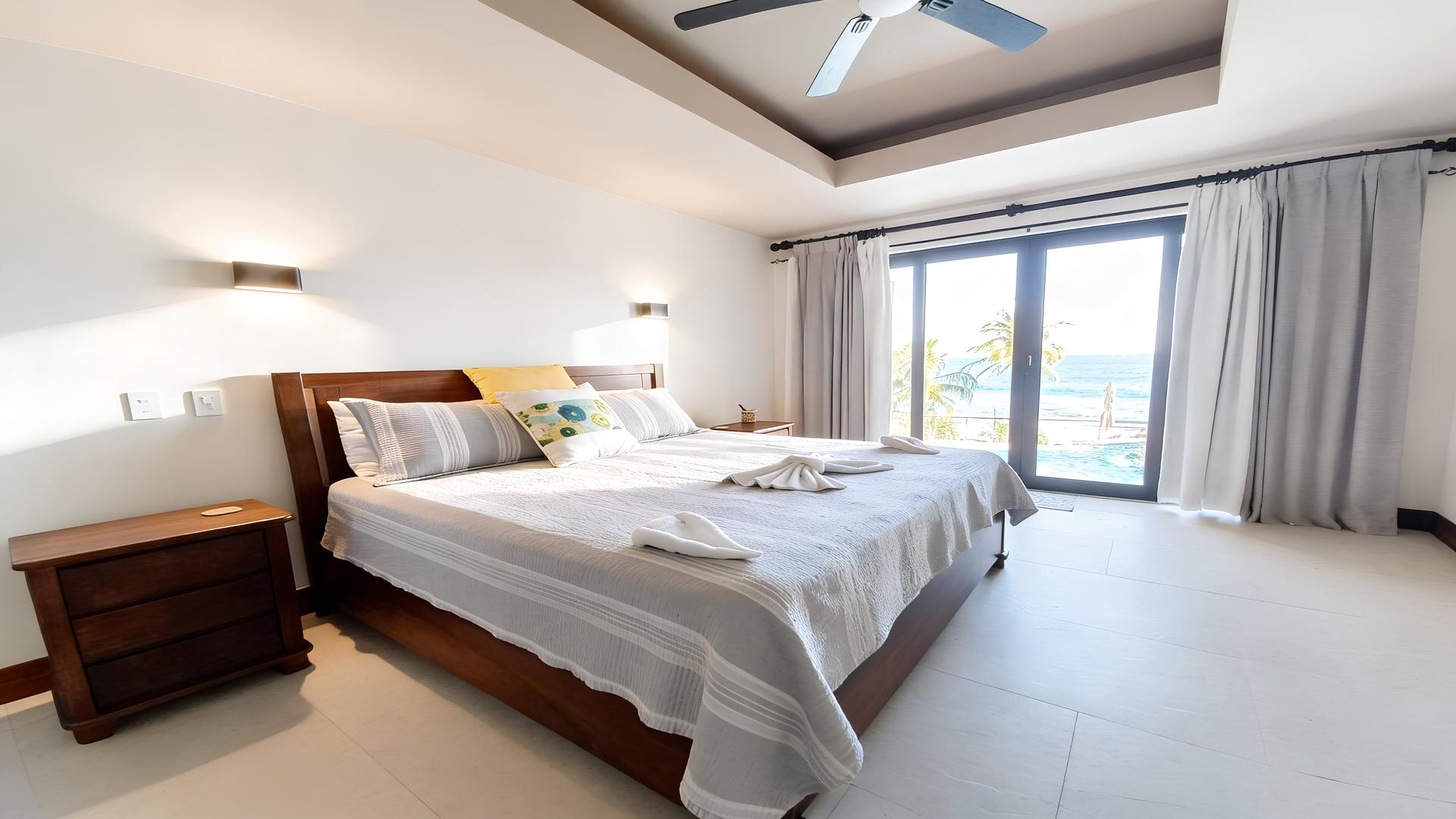 Primary bedroom with king bed, private balcony, and ocean views in a Costa Rica luxury beachfront villa
