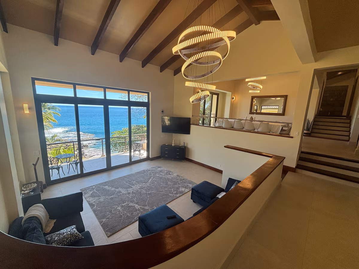 Luxury living room with floor-to-ceiling windows overlooking the Pacific Ocean in Costa Rica