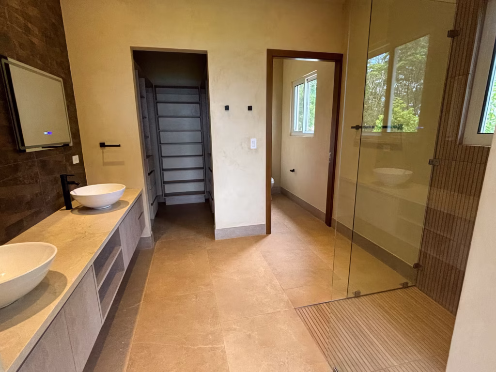 A spacious bathroom with a double vanity, walk-in shower, and modern finishes provides comfort and convenience for families.