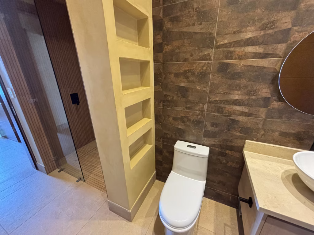 A spacious bathroom with a walk-in rain shower, vessel sink, and natural stone finishes designed for everyday comfort.