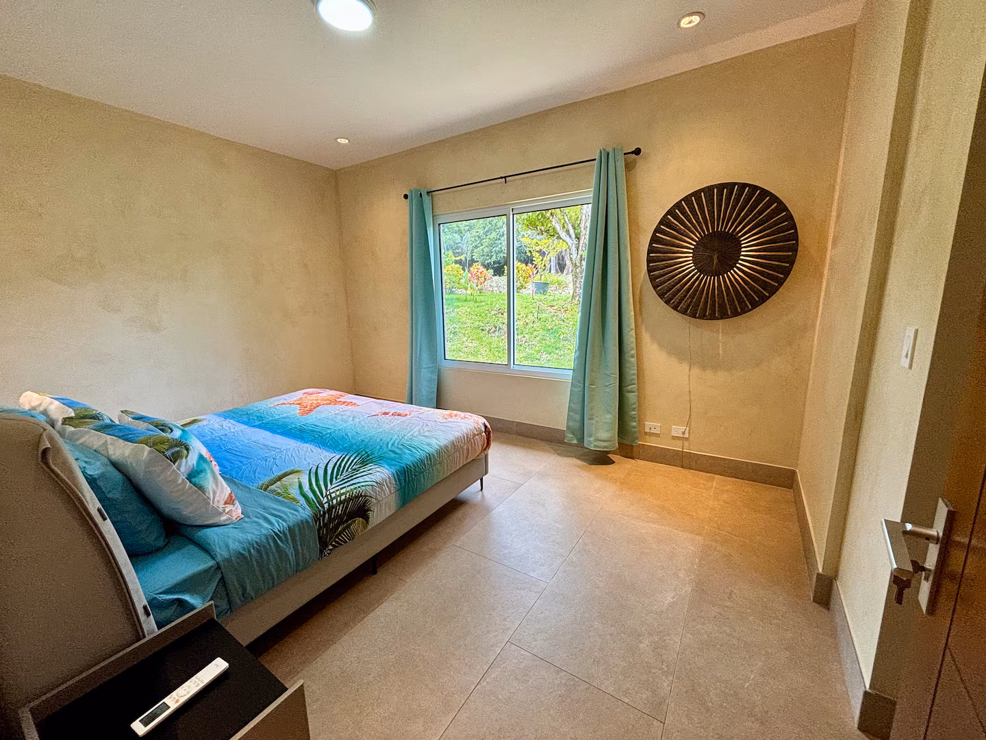 Guest bedroom with garden views, king bed, and large picture window in a Costa Rica vacation villa