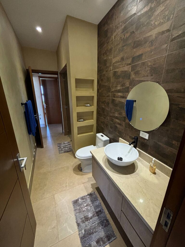 A modern ensuite bathroom features contemporary finishes, a vessel sink, and a spacious layout for added comfort.