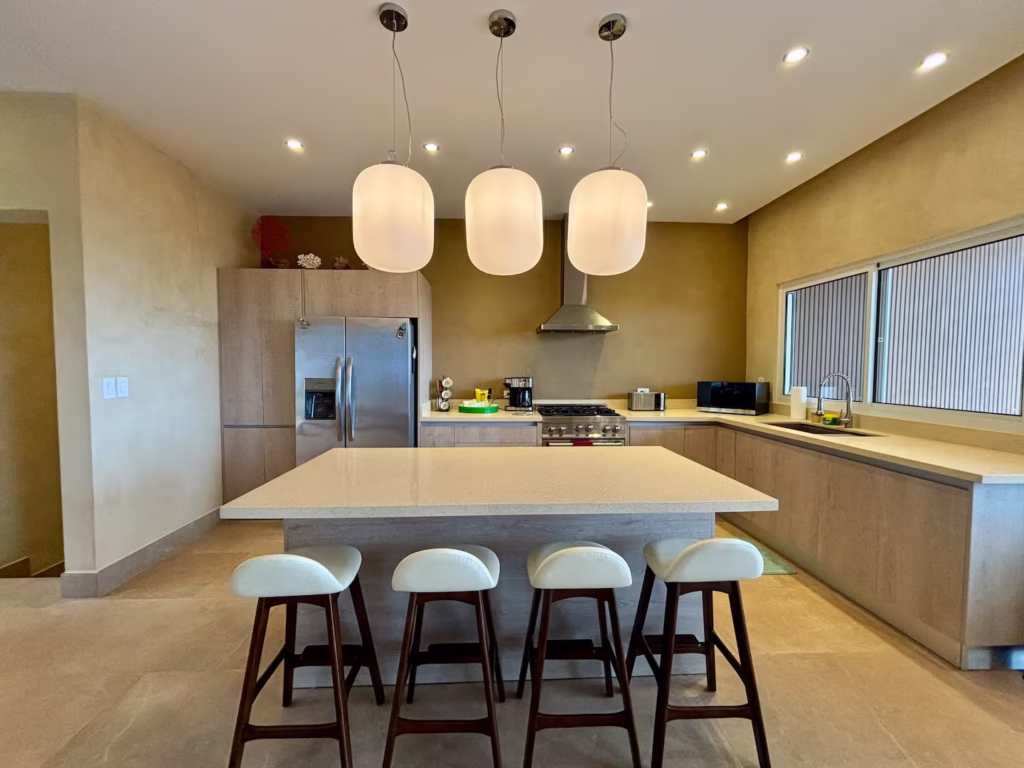 The fully equipped kitchen features a spacious island with seating for family breakfasts, casual meals, and planning the day's adventures together.