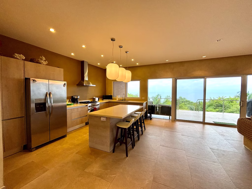 Open-concept kitchen with large island and Pacific Ocean views at a family vacation villa in Costa Rica