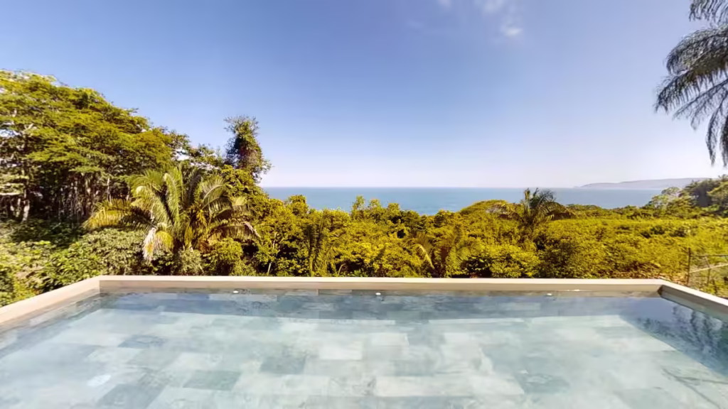The private pool overlooks the tropical forest canopy with peaceful Pacific Ocean views, creating a relaxing setting for families to unwind together.