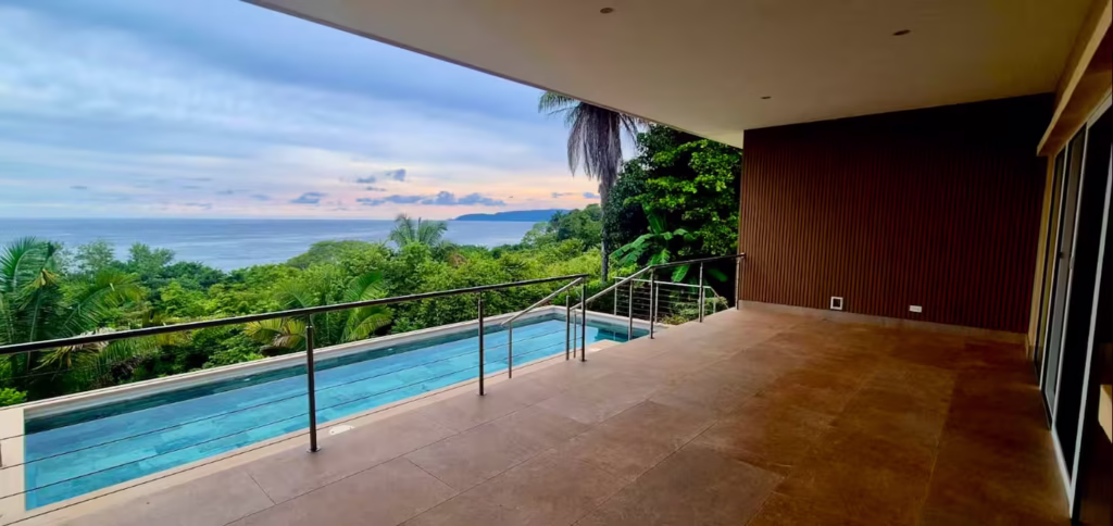 A spacious covered terrace overlooks the private pool and Pacific Ocean, creating the perfect outdoor gathering space for families and friends.